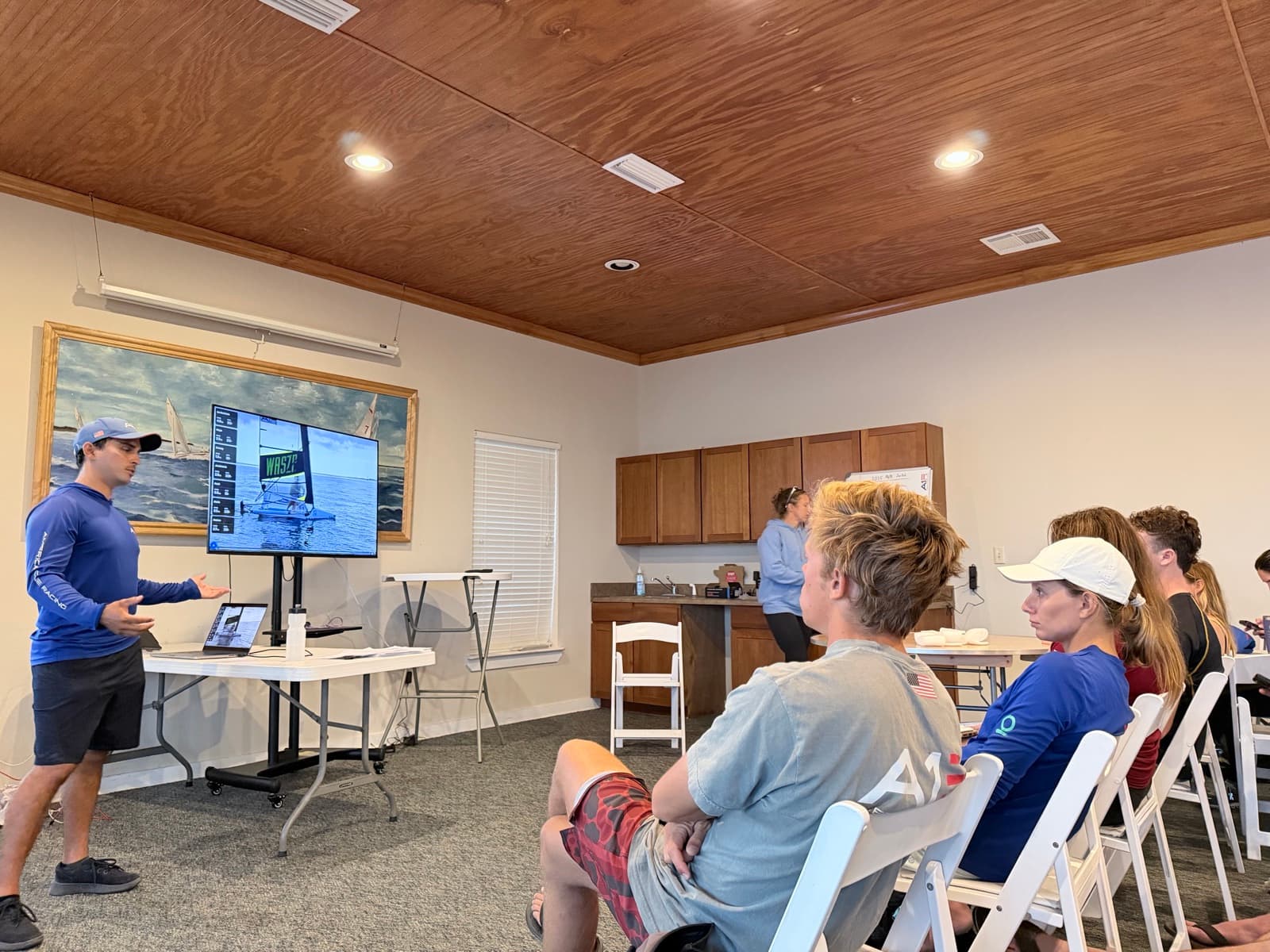 Coach presenting a ChartedSails replay to a club room of seated sailors